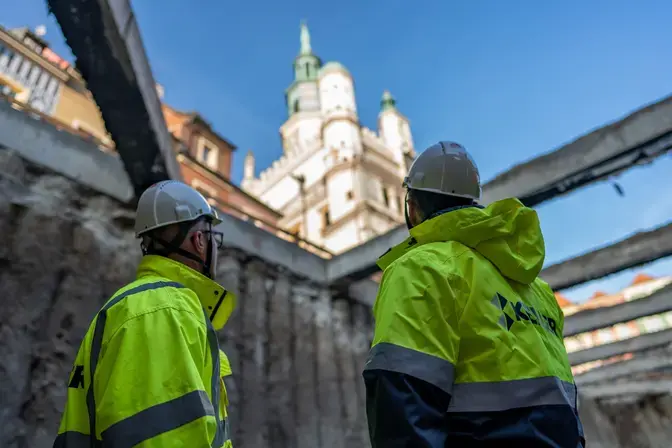 mężczyźni na placu budowy w odblaskowych kurtkach 