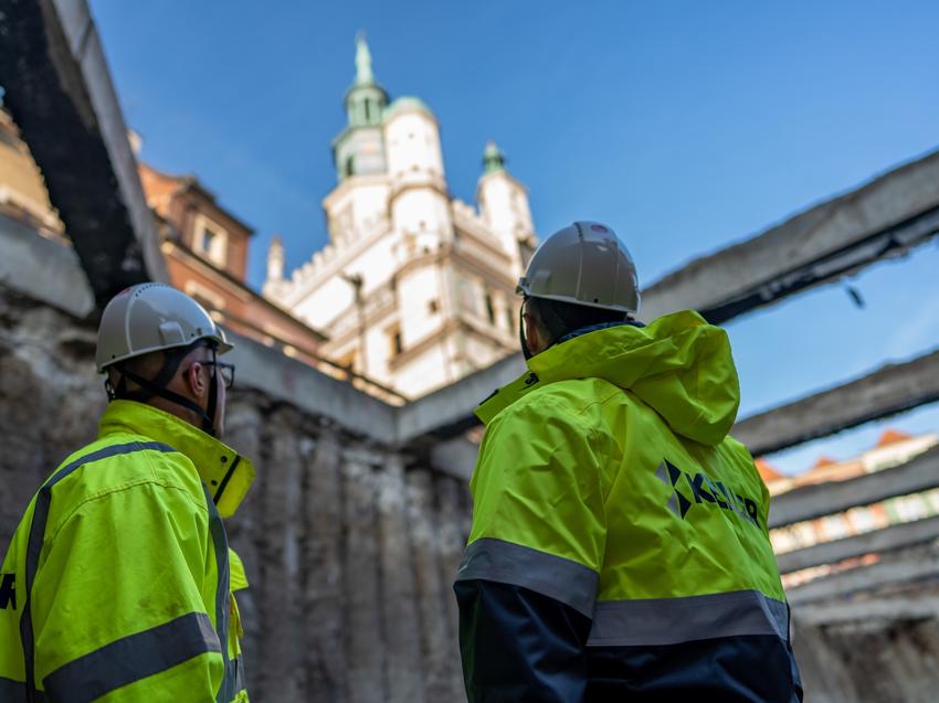 mężczyźni na placu budowy w odblaskowych kurtkach